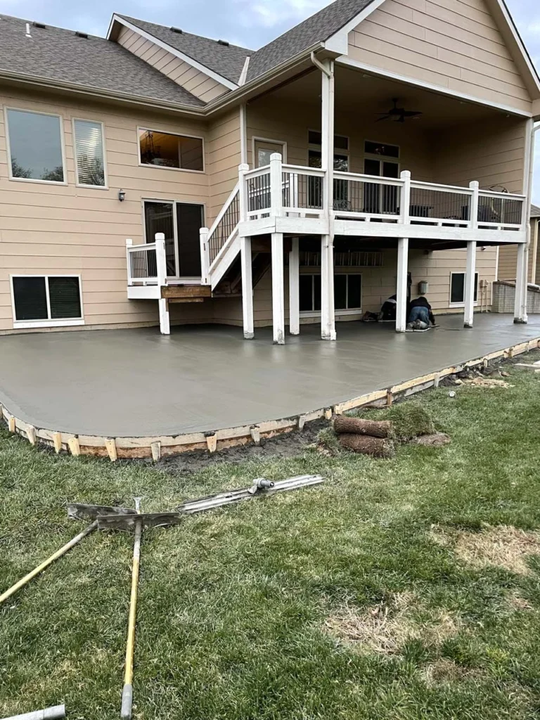 Finished curved concrete patio under a two-story deck