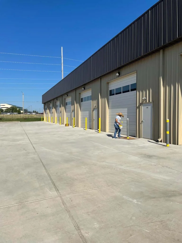 Finished metal shop building with overhead doors and a concrete apron