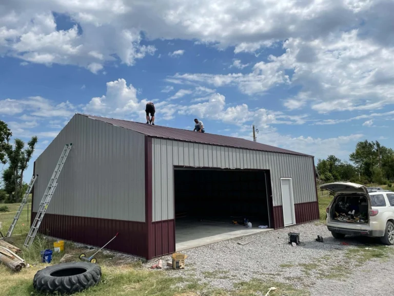 Crew finishing a two-tone metal garage building